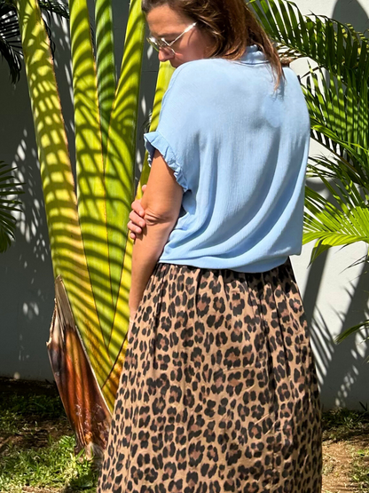 Vue arrière de la chemise bleu ciel en viscose douce, offrant une coupe élégante et intemporelle. Le nœud à la taille ajoute une finition délicate à cette pièce tendance et confortable. Ajoutez cette chemise à votre panier pour une livraison rapide et gratuite.
