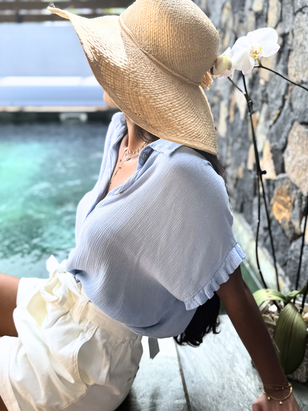 Zoom sur le détail du nœud à la taille de la chemise en viscose bleu ciel, apportant une touche féminine et stylée à votre look. Idéale pour une tenue élégante au quotidien. Commandez en ligne cette chemise et bénéficiez d'une livraison rapide et sécurisée.