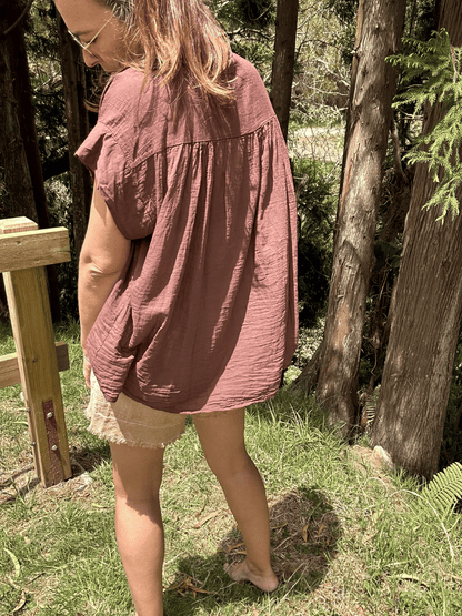 Vue de dos d’un top en voile de coton oversize, avec une coupe dégagée et un col V subtil. Ce vêtement intemporel et léger est une pièce incontournable pour toute garde-robe estivale. Découvrez-le sur notre boutique en ligne pour compléter vos looks de saison.