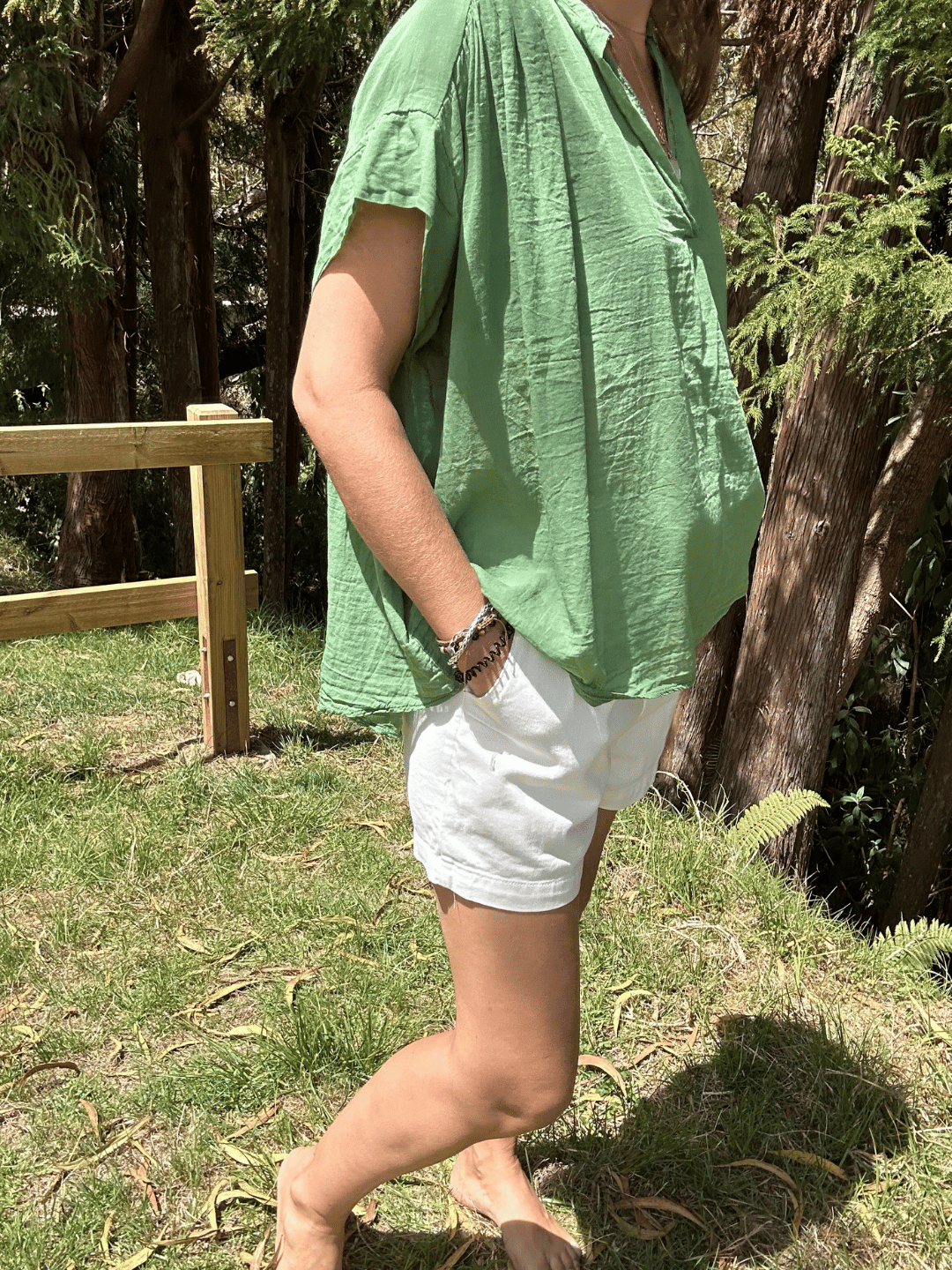 Zoom sur le top oversize en voile de coton olive avec col V. Un tissu léger, une coupe fluide et un style décontracté pour toutes vos occasions. Livraison gratuite pour toutes commandes en ligne.