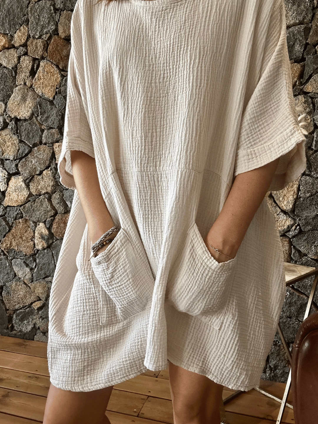 Zoom sur la robe en gaze de coton écru, ornée de deux poches avant. Légère et polyvalente, elle est idéale pour toutes les occasions. Profitez de la livraison gratuite en commandant sur notre site.