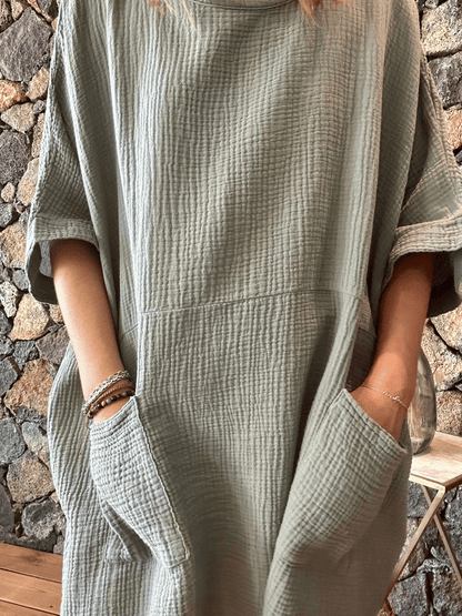 Zoom sur la robe en gaze de coton kaki avec ses deux poches avant, une pièce chic et fonctionnelle. Idéale pour toutes les occasions. Profitez de la livraison gratuite en commandant en ligne.